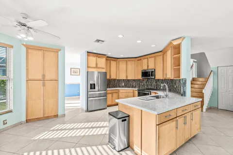 a kitchen with stainless steel appliances granite countertop a refrigerator sink and stove