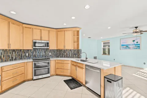 a kitchen with granite countertop white cabinets and white appliances