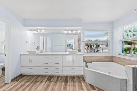 a bathroom with a granite countertop sink mirror and a bathtub