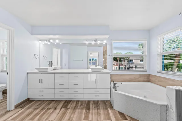 a bathroom with a granite countertop sink mirror and a bathtub