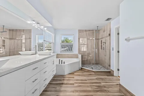 a bathroom with a double vanity sink mirror double and a bathtub