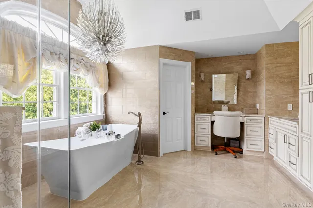 a car parked in front of a house with potted plants and a bench