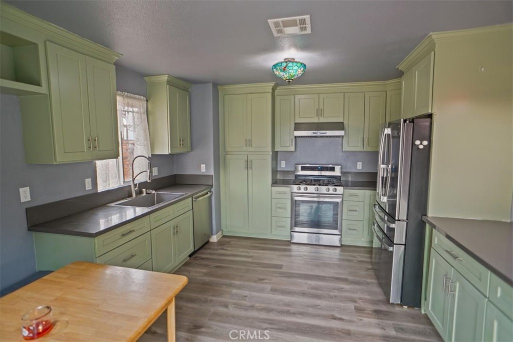 40287 Fieldspring Street Palmdale, CA 93591 - Photo 4 of 14 a kitchen with kitchen island white cabinets a refrigerator and a stove