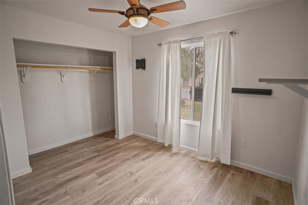 40287 Fieldspring Street Palmdale, CA 93591 - Photo 7 of 14 an empty room with wooden floor fan and windows