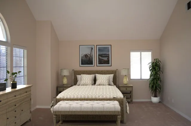 a bedroom with a bed and a potted plant on dresser