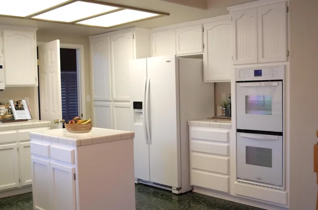 a kitchen with a refrigerator sink stove and cabinets