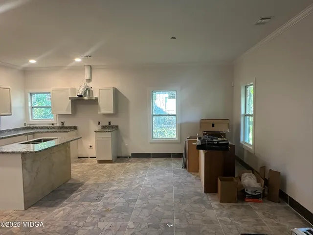 a kitchen with granite countertop a sink stove and refrigerator