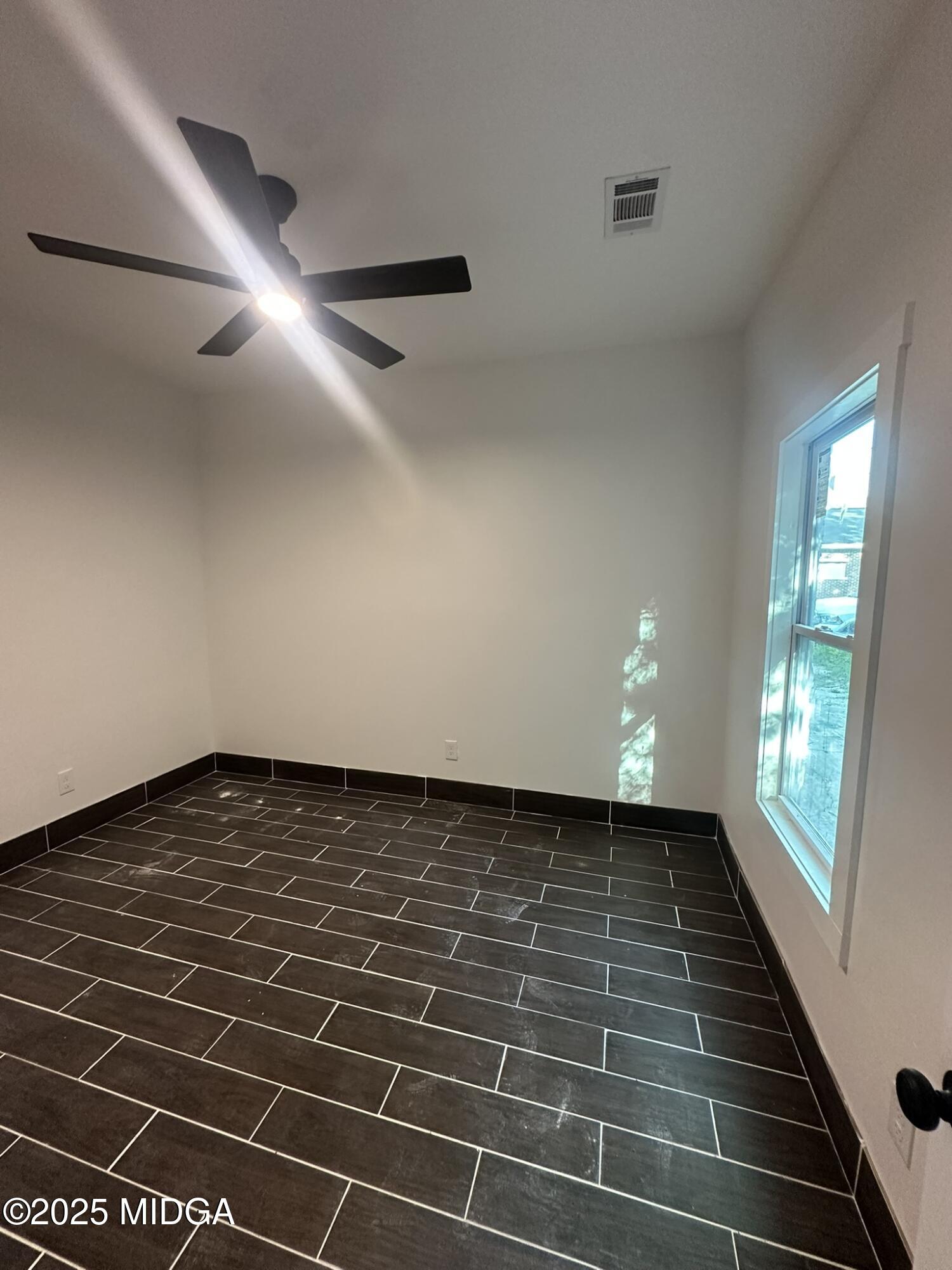 320 Lincoln Avenue Macon, GA 31201 - Photo 8 of 11 a view of an empty room with wooden floor and a window