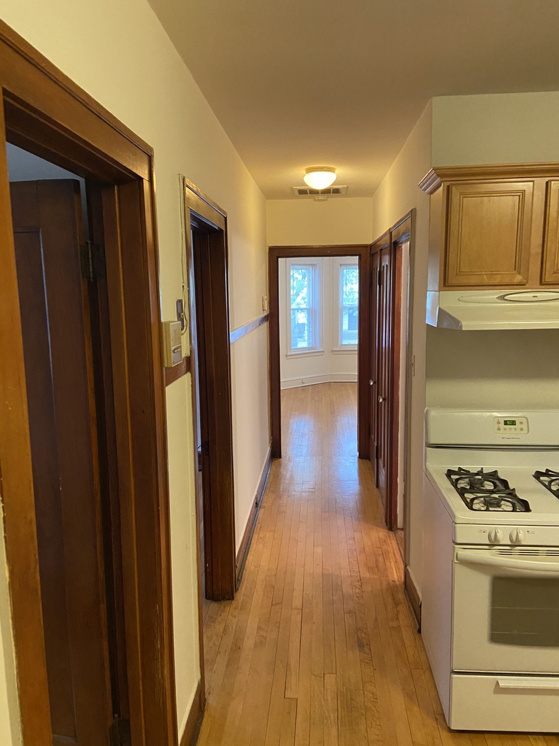 2143 West Superior Street, Unit 2F Chicago, IL 60612 - Photo 4 of 10 a view of a hallway with wooden floor and electronic appliances