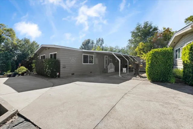 a view of a house with backyard and trees