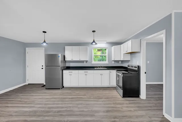 a kitchen with stainless steel appliances granite countertop a refrigerator and a stove top oven