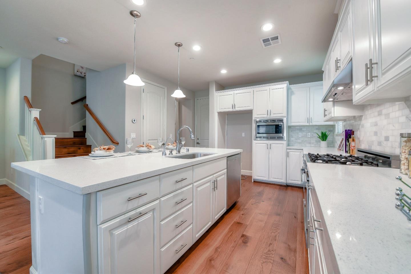 171 Cobblestone Loop Milpitas, CA 95035 - Photo 7 of 41 a large kitchen with stainless steel appliances kitchen island a large counter top a stove a chimney a sink and a refrigerator