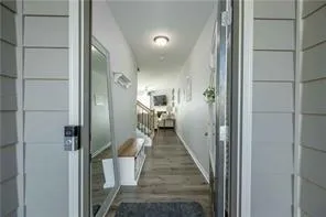 a view of a hallway with wooden floor and staircase