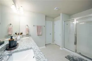 a bathroom with a granite countertop sink a mirror and shower