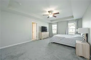 a spacious bedroom with a large bed a chandelier and closet