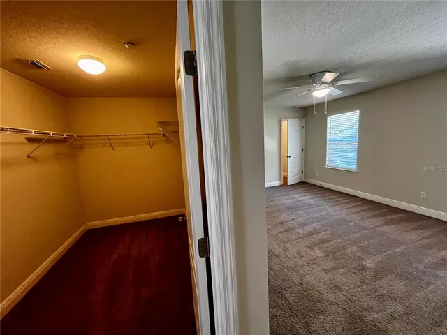 an empty room with windows and fan