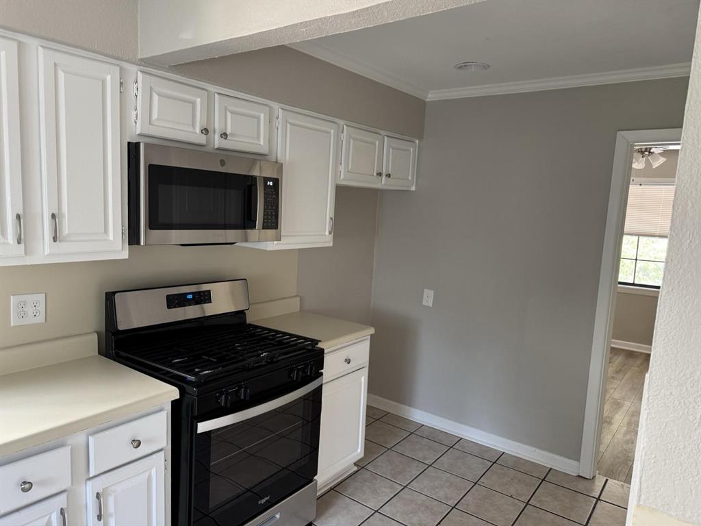 8427 Ridgelea Street Dallas, TX 75209 - Photo 5 of 17 a kitchen with granite countertop white cabinets and black appliances