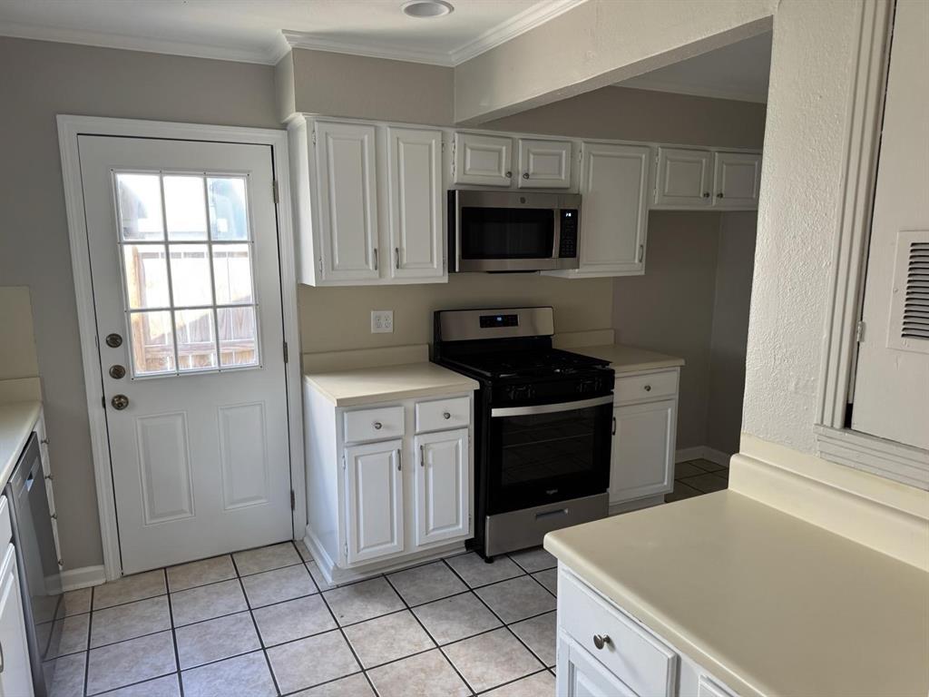 8427 Ridgelea Street Dallas, TX 75209 - Photo 7 of 17 a kitchen with white cabinets and black appliances