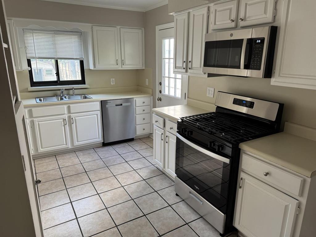 8427 Ridgelea Street Dallas, TX 75209 - Photo 10 of 17 a kitchen with granite countertop a stove sink and microwave