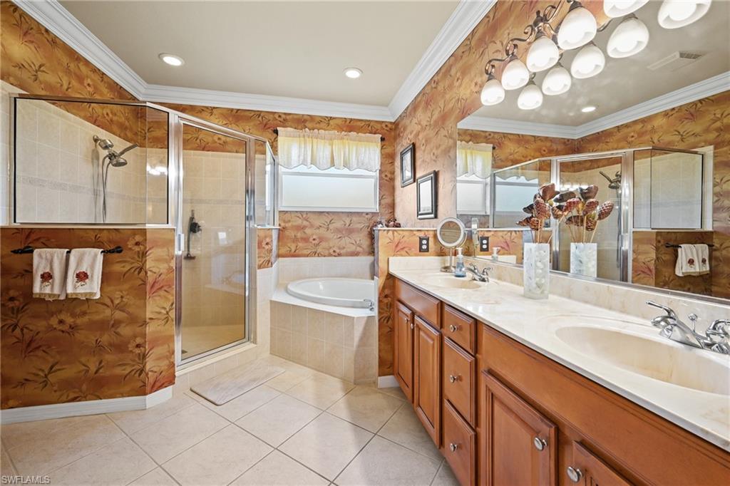 20674 Larino Loop Estero, FL 33928 - Photo 28 of 50 a spacious bathroom with a double vanity sink a mirror and a bathtub