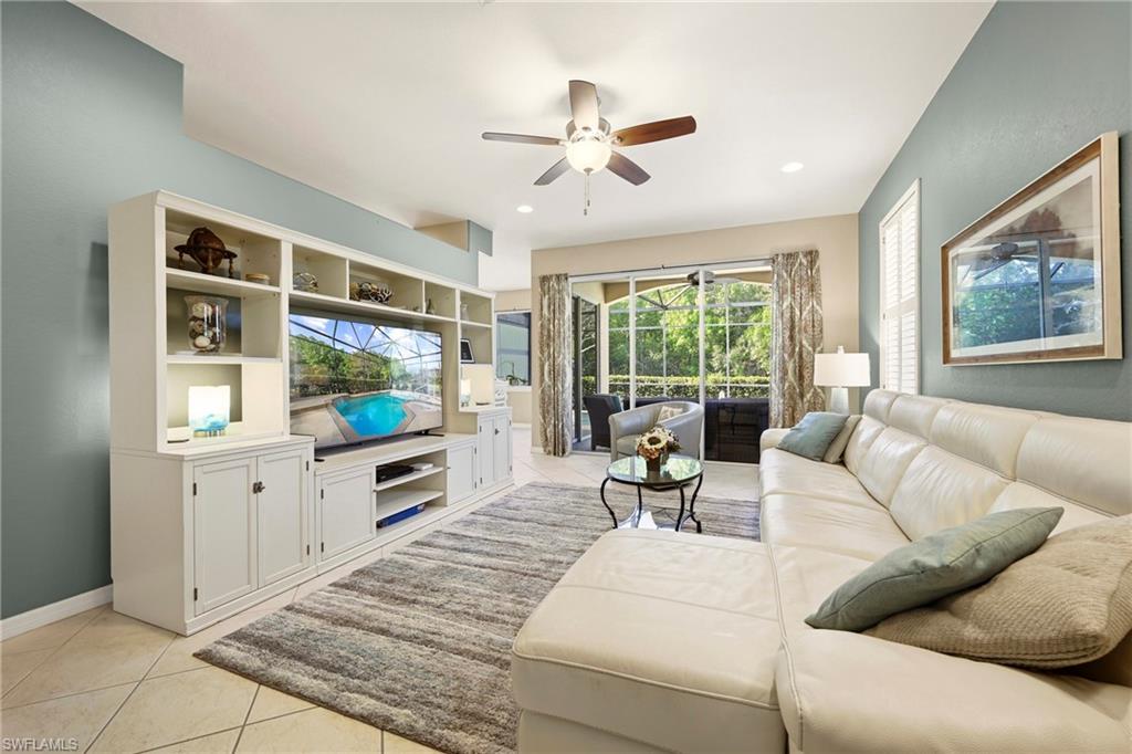 20674 Larino Loop Estero, FL 33928 - Photo 4 of 50 a living room with furniture a flat screen tv and a floor to ceiling window