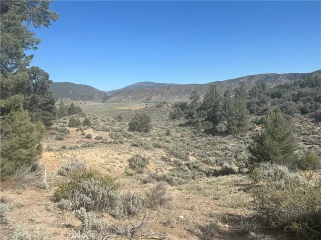 a view of a large mountain with mountains in the background