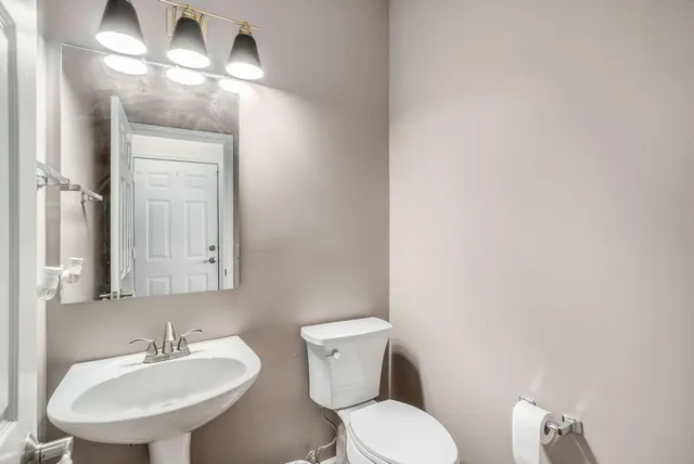 a bathroom with a toilet a sink and mirror