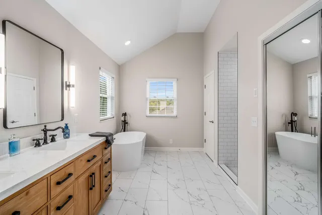 a spacious bathroom with a double vanity sink a mirror and a bathtub
