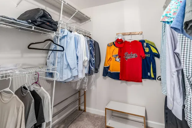 a view of walk in closet with clothes and shoes