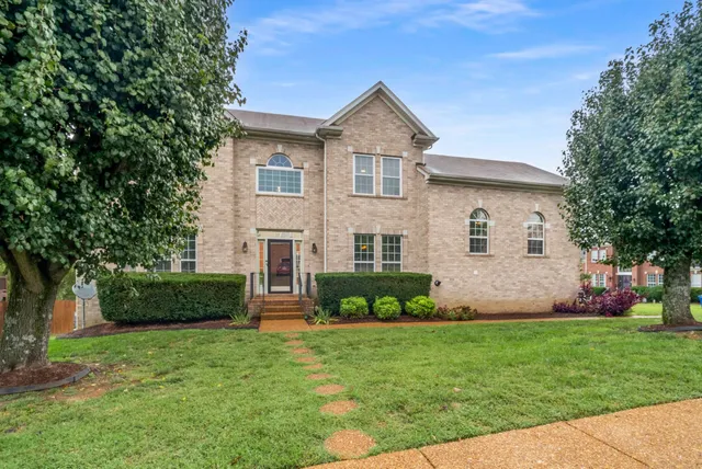 a front view of a house with a garden and plants