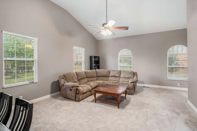 a living room with furniture a chandelier and a window