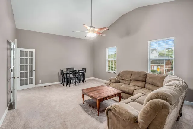 a living room with furniture a dining table and a window