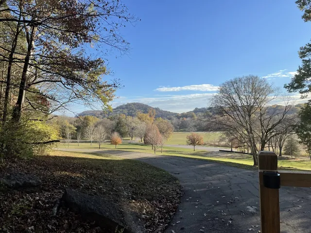 a front view of a building with garden and trees