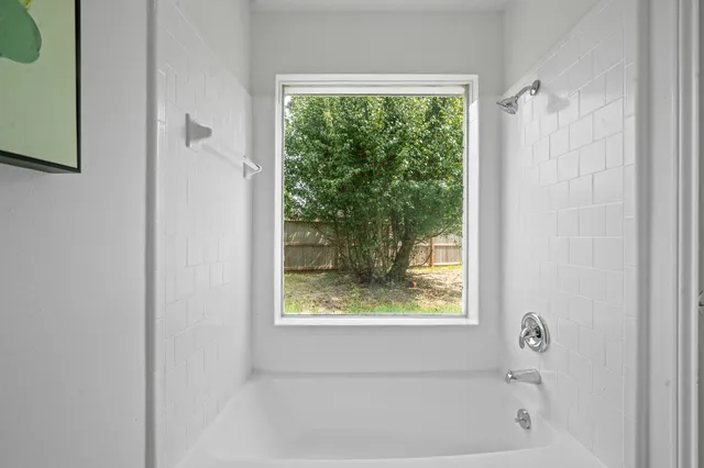 a bathroom with a bathtub and window
