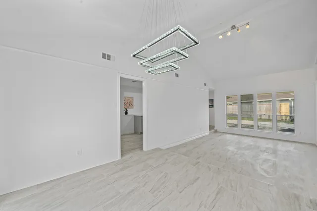 a view of empty room with wooden floor and ceiling fan