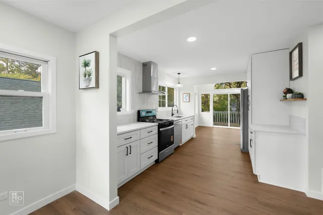 a large kitchen with a lot of counter space and wooden floor