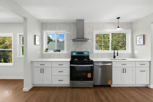 a kitchen with stainless steel appliances a stove sink and wooden floor