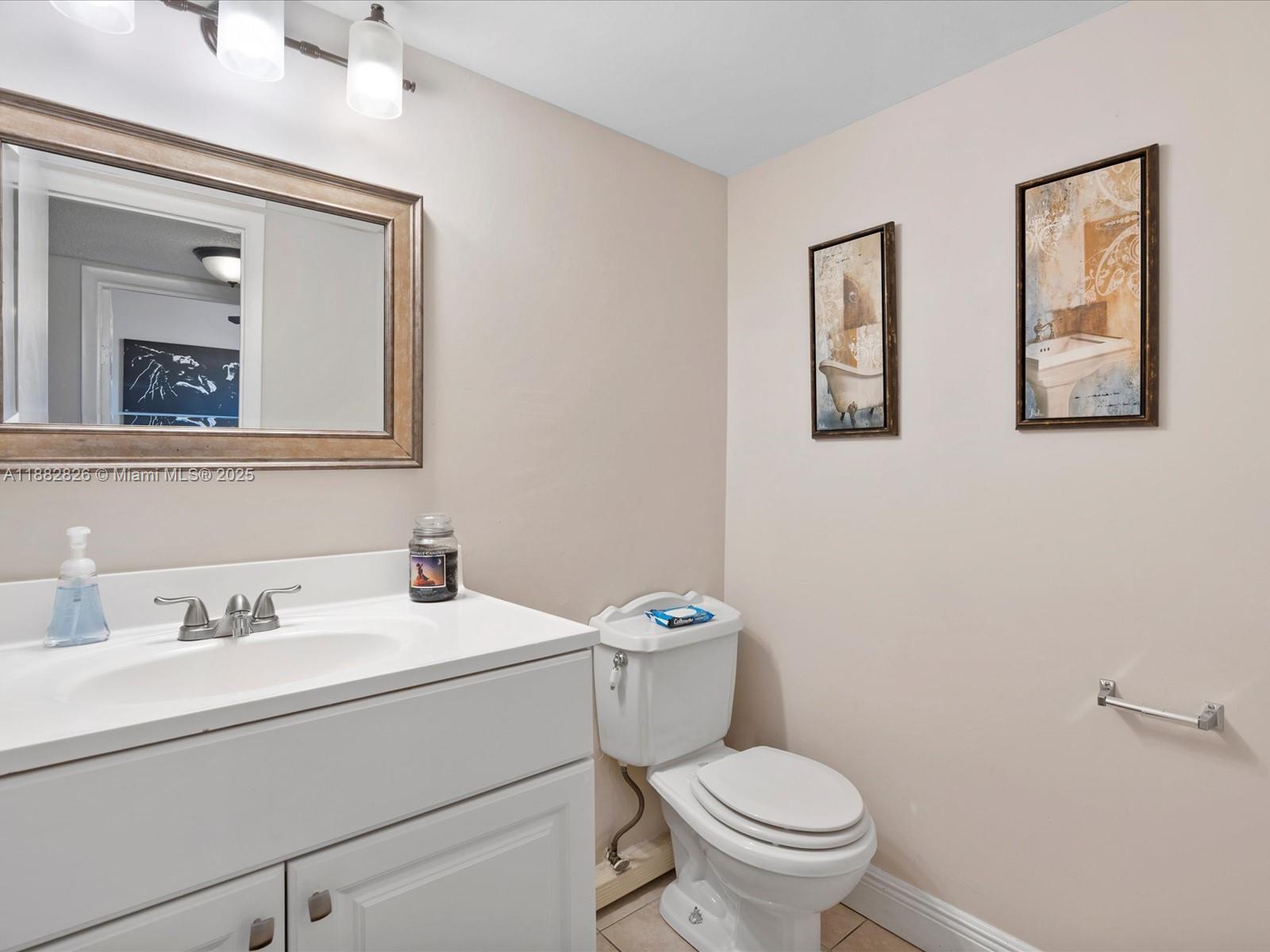 8401 West Sample Road, Unit 28 Coral Springs, FL 33065 - Photo 15 of 17 a bathroom with a toilet sink and mirror