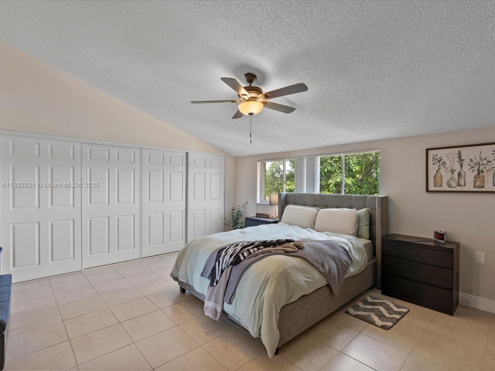 8401 West Sample Road, Unit 28 Coral Springs, FL 33065 - Photo 10 of 17 a spacious bedroom with a bed and a chandelier