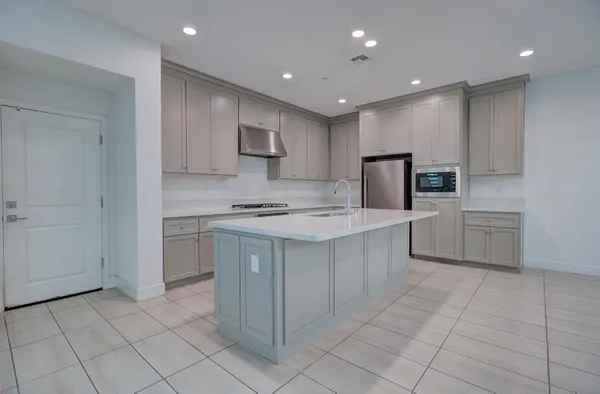 a kitchen with white cabinets a sink and white appliances