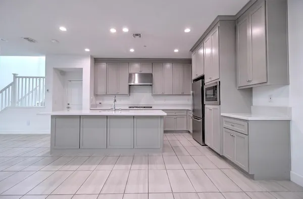 a kitchen with kitchen island granite countertop stainless steel appliances cabinets a sink and a counter top space