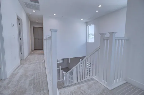 a view of a hallway with entryway and stairs