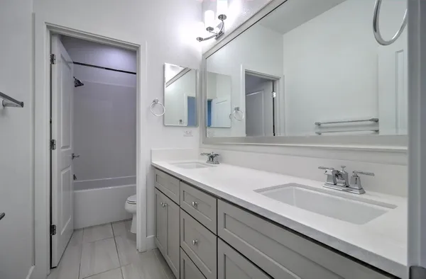 a bathroom with a double vanity sink mirror double and shower