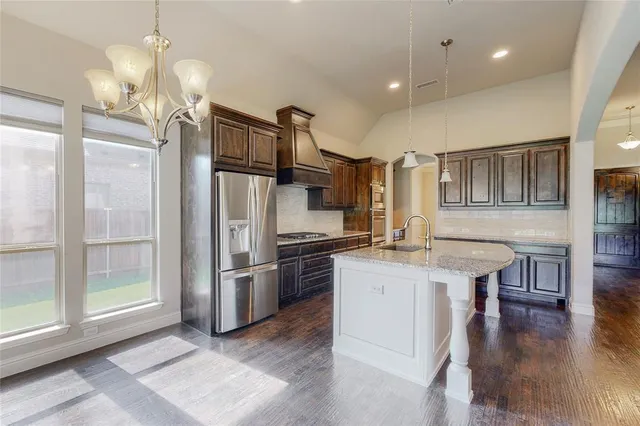 a kitchen with granite countertop a refrigerator and wooden cabinets