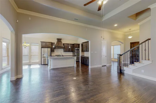 a view of an empty room with wooden floor a fireplace and a window