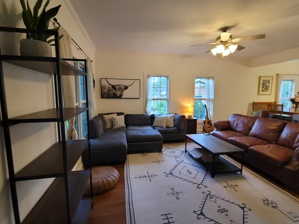 a living room with furniture a chandelier and a window