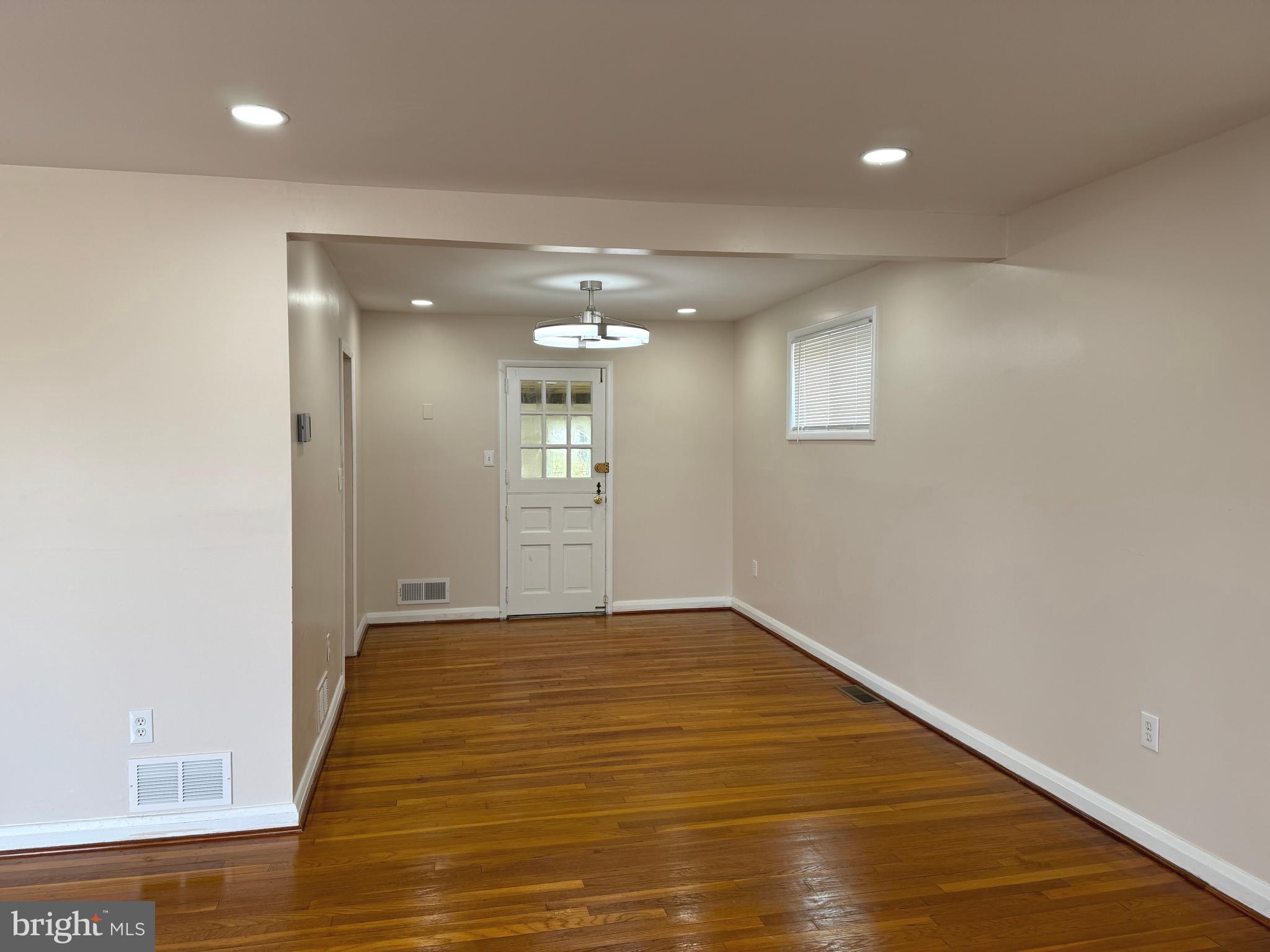 609 Wallerson Road Baltimore, MD 21228 - Photo 13 of 15 an empty room with wooden floor and windows