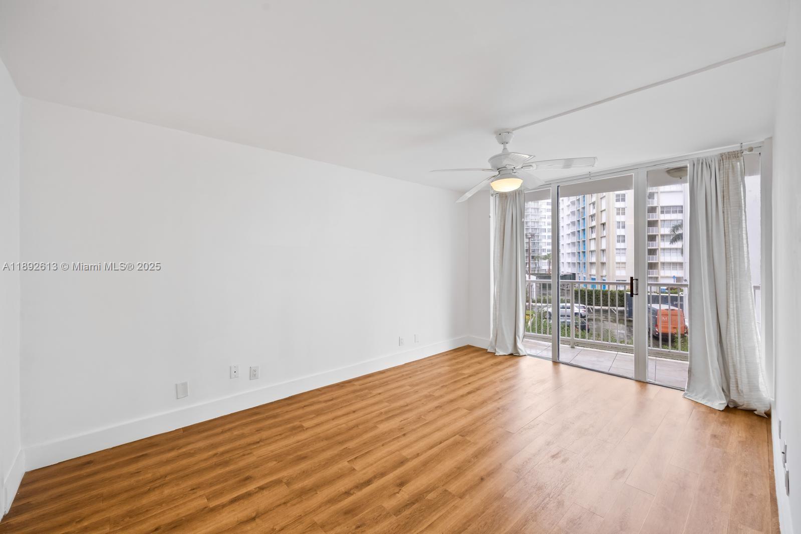 1440 Brickell Bay Drive, Unit 307 Miami, FL 33131 - Photo 12 of 28 wooden floor in an empty room with a window