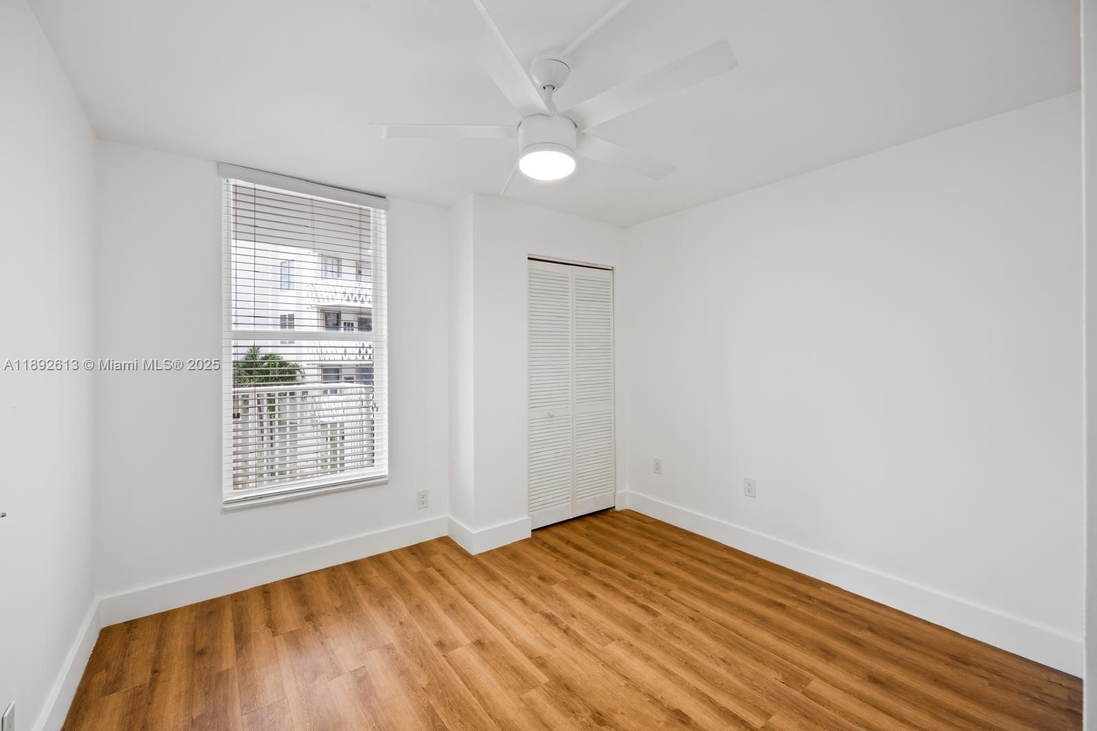 1440 Brickell Bay Drive, Unit 307 Miami, FL 33131 - Photo 18 of 28 a view of empty room with wooden floor and fan