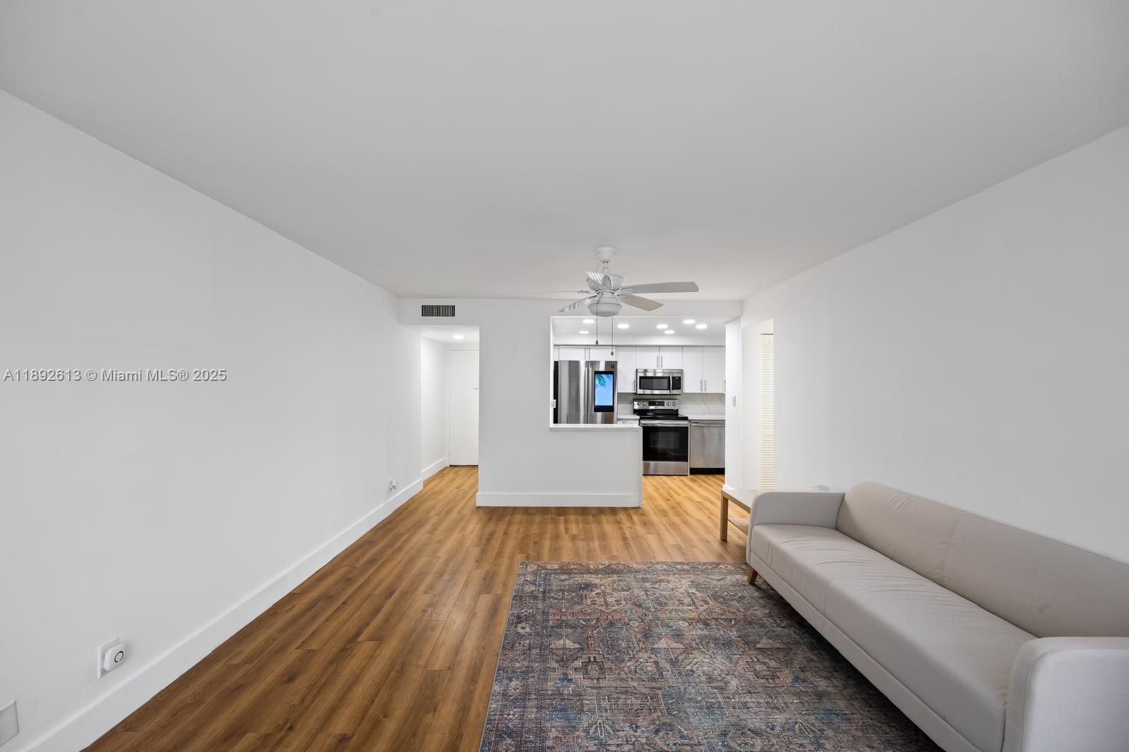 1440 Brickell Bay Drive, Unit 307 Miami, FL 33131 - Photo 5 of 28 a living room with furniture and a wooden floor